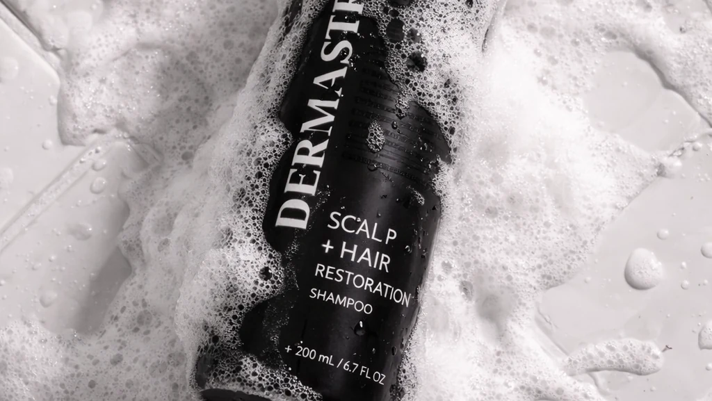 The DERMASTRAND bottle in a lather of foam